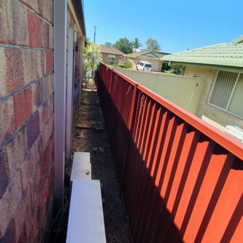 Side path cleared along a red fence